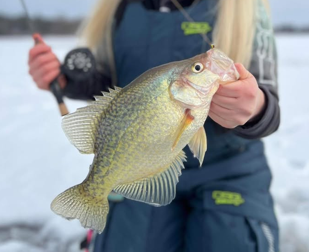 Friends ice fishing at winter sunrise on a Michigan lake