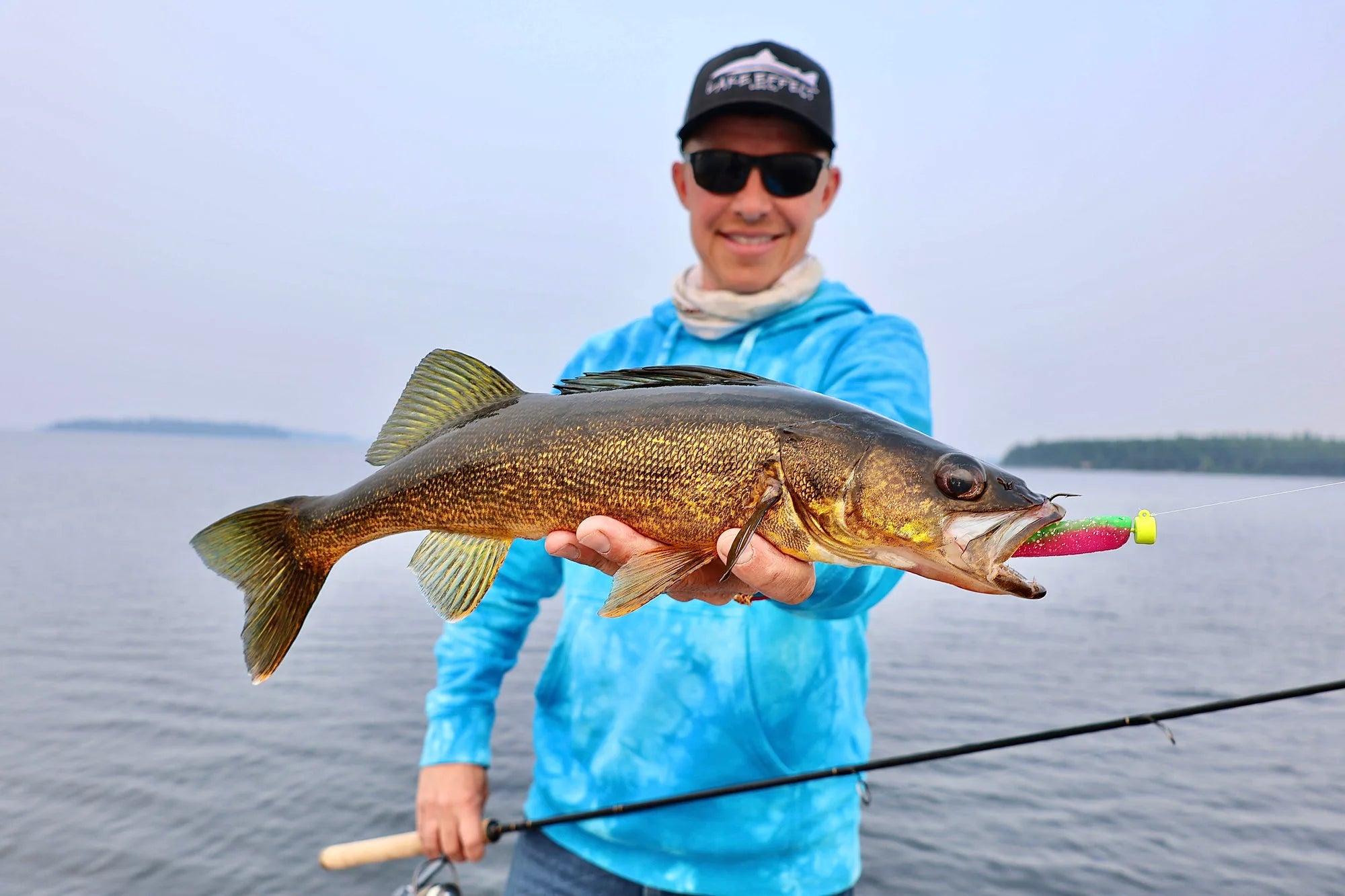 Hero — open-water walleye catch, Lake Effect hat, lure in mouth